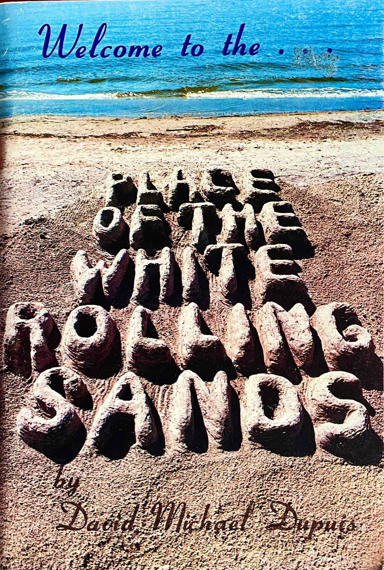 Cover of The Place of the White Rolling Sands — the title modelled in beach sand before the waves of Georgian Bay